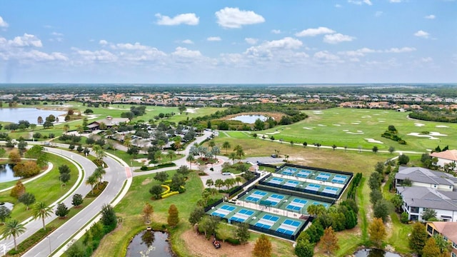 drone / aerial view with a water view and golf course view