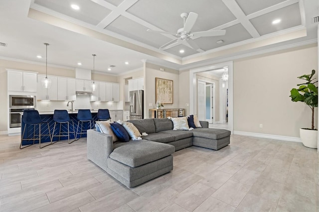 living area featuring ceiling fan, crown molding, coffered ceiling, and baseboards