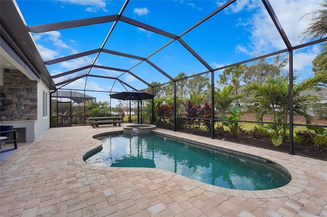 view of swimming pool featuring glass enclosure, a patio area, and a pool with connected hot tub