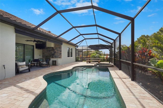 view of swimming pool with a lanai, ceiling fan, a pool with connected hot tub, and a patio