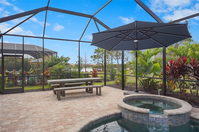 view of patio / terrace with a lanai and an in ground hot tub