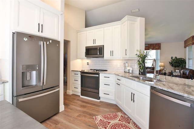 kitchen featuring light hardwood / wood-style floors, sink, stainless steel appliances, backsplash, and white cabinets