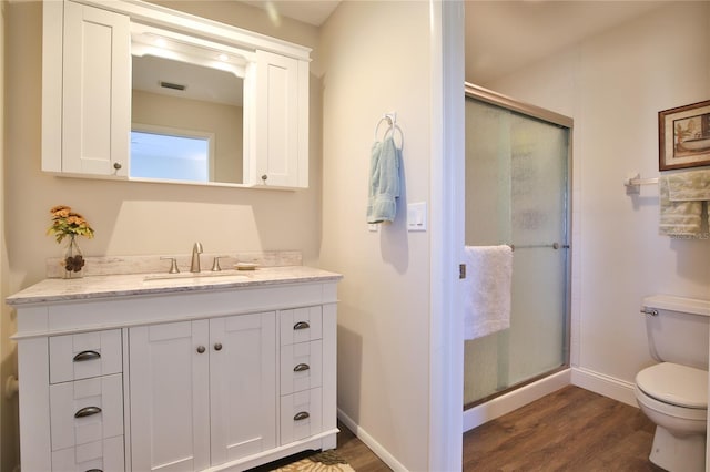 bathroom featuring an enclosed shower, wood-type flooring, vanity, and toilet