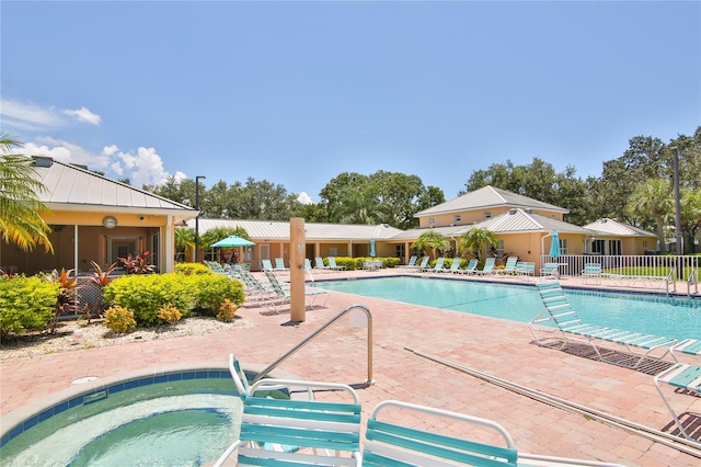 view of pool with a patio and a hot tub