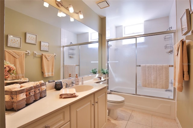 full bathroom featuring tile patterned floors, vanity, toilet, and combined bath / shower with glass door