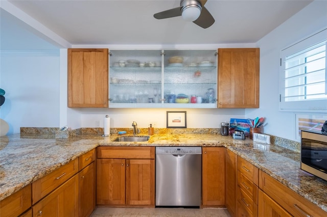 kitchen with light stone countertops, appliances with stainless steel finishes, sink, and ceiling fan