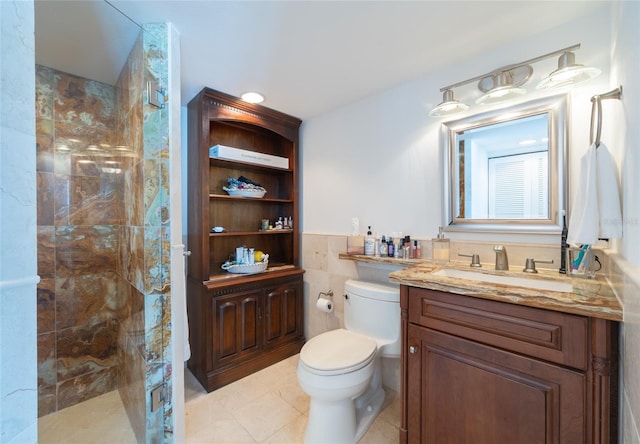 bathroom featuring tile walls, vanity, toilet, and tiled shower