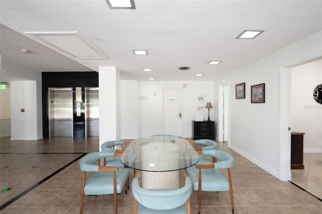 dining room featuring a textured ceiling, elevator, and light tile patterned flooring