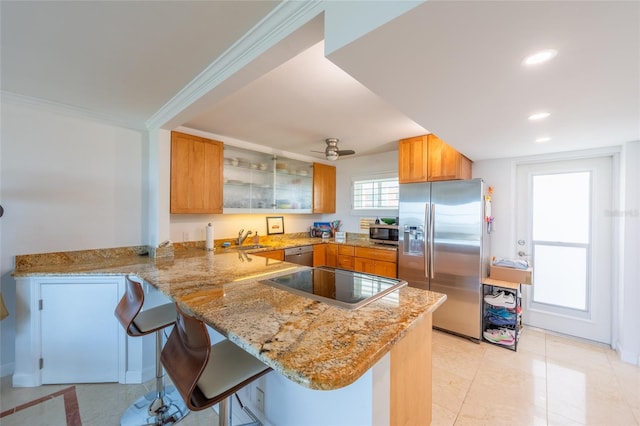 kitchen featuring appliances with stainless steel finishes, sink, a kitchen breakfast bar, and kitchen peninsula