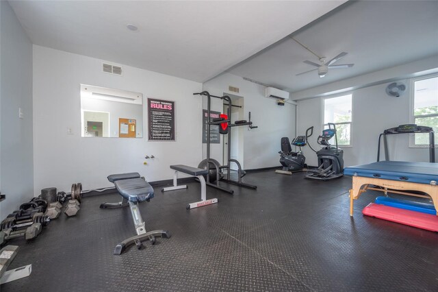 exercise room with ceiling fan and a wall mounted air conditioner