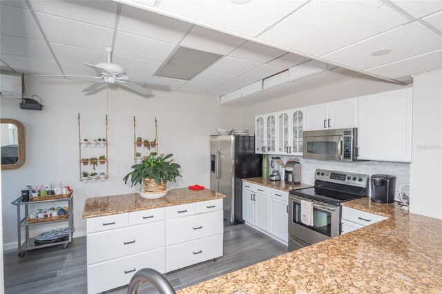 kitchen with white cabinets, stainless steel appliances, dark hardwood / wood-style flooring, and a drop ceiling