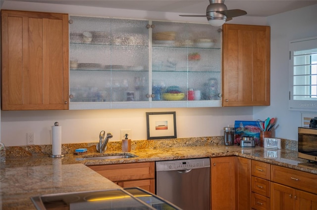 kitchen with light stone counters, ceiling fan, stainless steel appliances, and sink