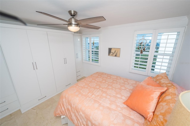 bedroom with multiple windows, ornamental molding, ceiling fan, and a closet