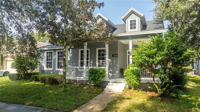 view of front facade with french doors, stucco siding, a porch, and a front lawn