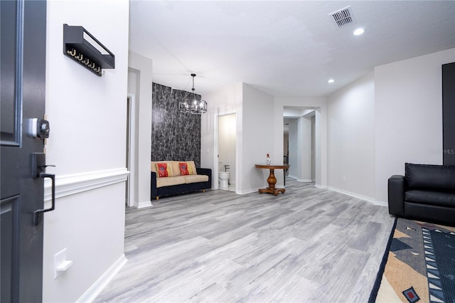 living area featuring light hardwood / wood-style flooring and a chandelier