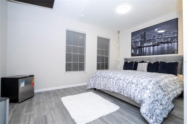 bedroom featuring hardwood / wood-style floors and stainless steel refrigerator