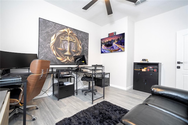 home office with light hardwood / wood-style flooring and ceiling fan