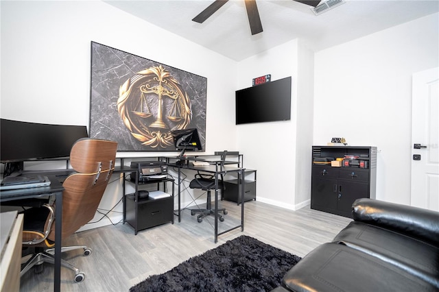 office with light wood-type flooring and ceiling fan