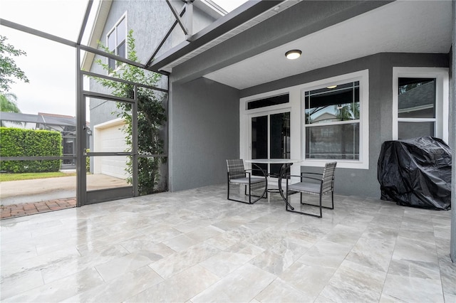 view of patio with grilling area and glass enclosure