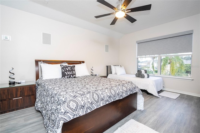 bedroom with visible vents, lofted ceiling, baseboards, ceiling fan, and light wood-style flooring