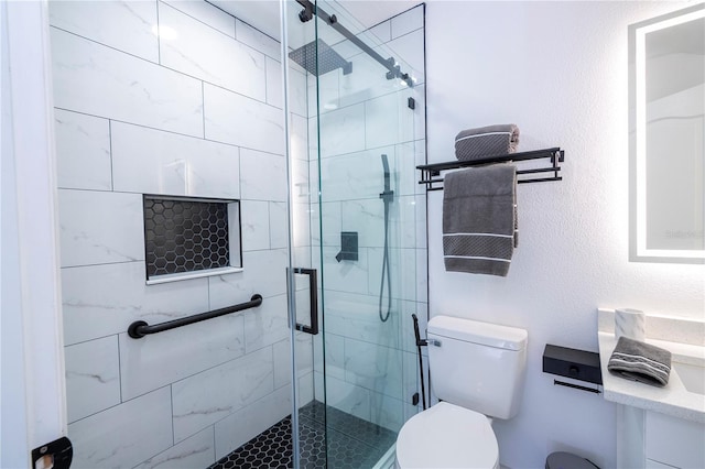 bathroom featuring a shower with door and toilet