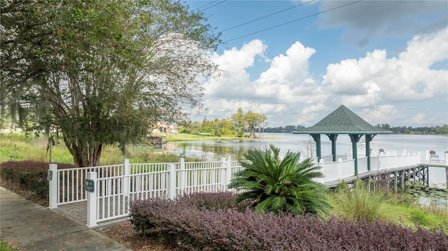 view of dock with a gazebo and a water view