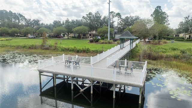 dock area with a water view and a lawn