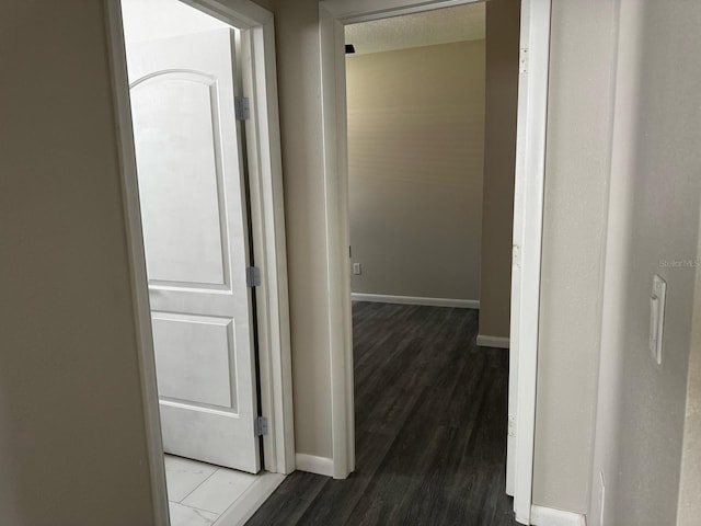 hallway with baseboards and wood finished floors