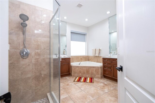 full bathroom featuring vanity, tile patterned floors, a shower stall, visible vents, and a bath