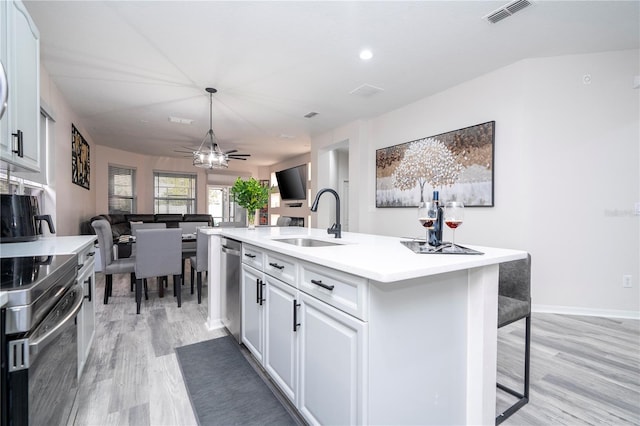 kitchen with a ceiling fan, visible vents, light wood-type flooring, a sink, and stainless steel appliances