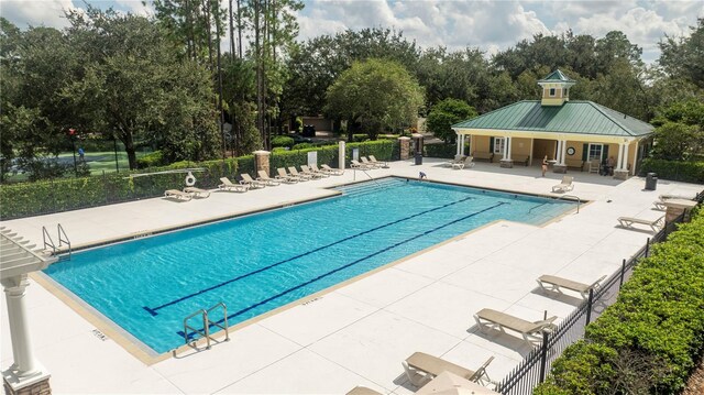 community pool with fence and a patio