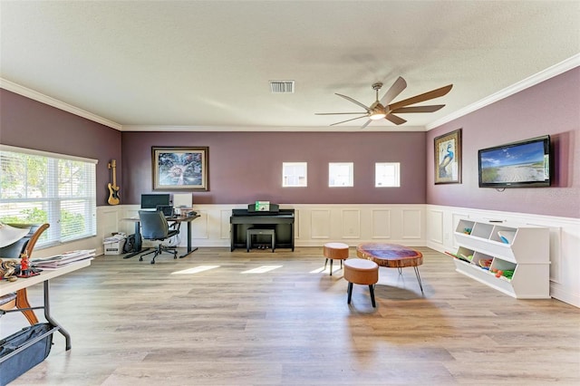 playroom featuring a textured ceiling, ceiling fan, light hardwood / wood-style floors, and crown molding