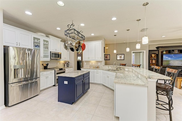 kitchen featuring a breakfast bar, a center island, white cabinets, appliances with stainless steel finishes, and kitchen peninsula