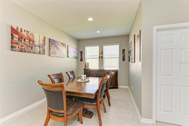 tiled dining area with a textured ceiling