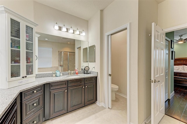 bathroom with vanity, a shower with door, ceiling fan, wood-type flooring, and toilet