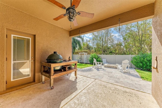 view of patio / terrace featuring ceiling fan and a fire pit