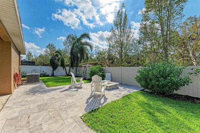 view of yard featuring a patio, central AC unit, and an outdoor fire pit