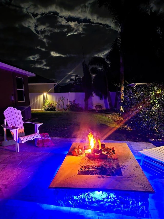 pool at twilight featuring a fire pit and a patio