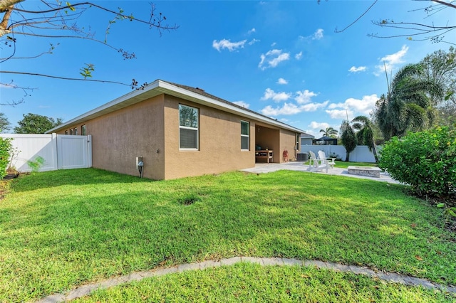 rear view of house with a lawn and a patio