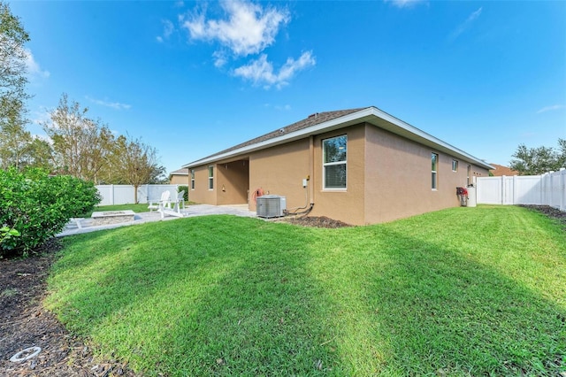 rear view of property with central air condition unit, a patio area, and a yard