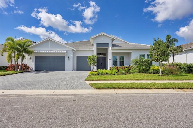 view of front of property featuring a front lawn and a garage