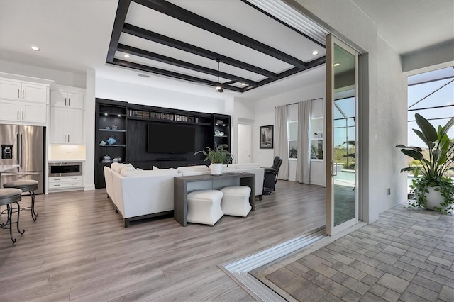 living room with light hardwood / wood-style flooring and beamed ceiling