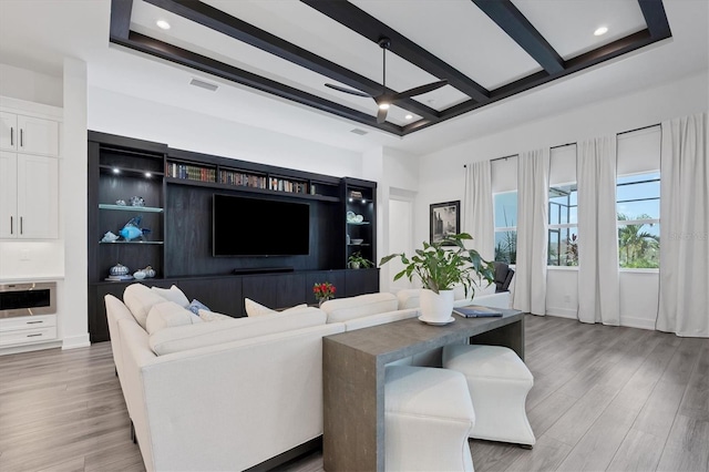 living room with beam ceiling, hardwood / wood-style floors, ceiling fan, and a raised ceiling