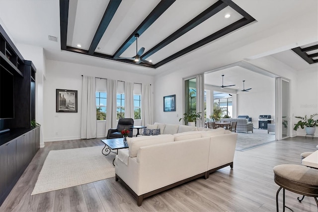 living room with hardwood / wood-style flooring, beamed ceiling, and a tray ceiling