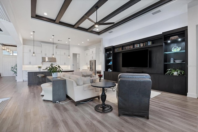 living room featuring beamed ceiling, light wood-type flooring, and ceiling fan