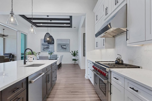 kitchen with sink, appliances with stainless steel finishes, decorative light fixtures, and white cabinets