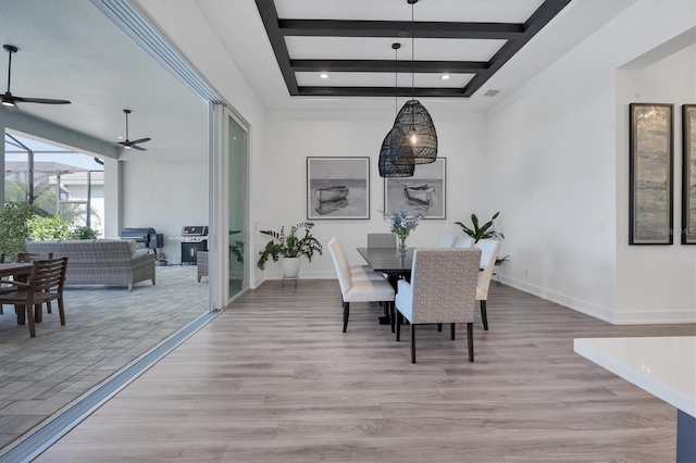 dining area with light hardwood / wood-style flooring, beamed ceiling, and ceiling fan