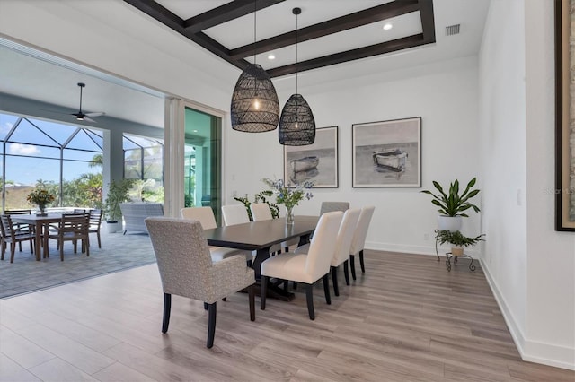 dining room featuring beam ceiling, light hardwood / wood-style floors, and ceiling fan