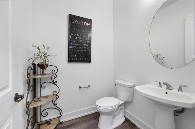 bathroom with toilet and hardwood / wood-style floors