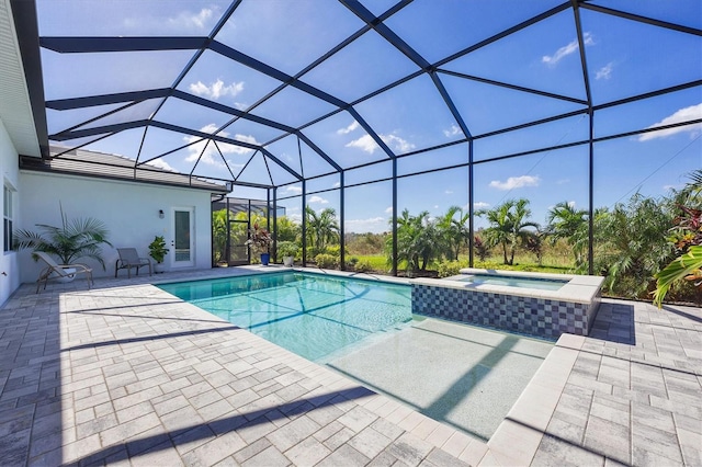 view of swimming pool featuring an in ground hot tub, a patio area, and a lanai